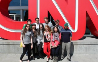 Students standing in front of red CNN letters