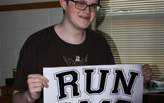 Boy holding Run DMC white and black sign