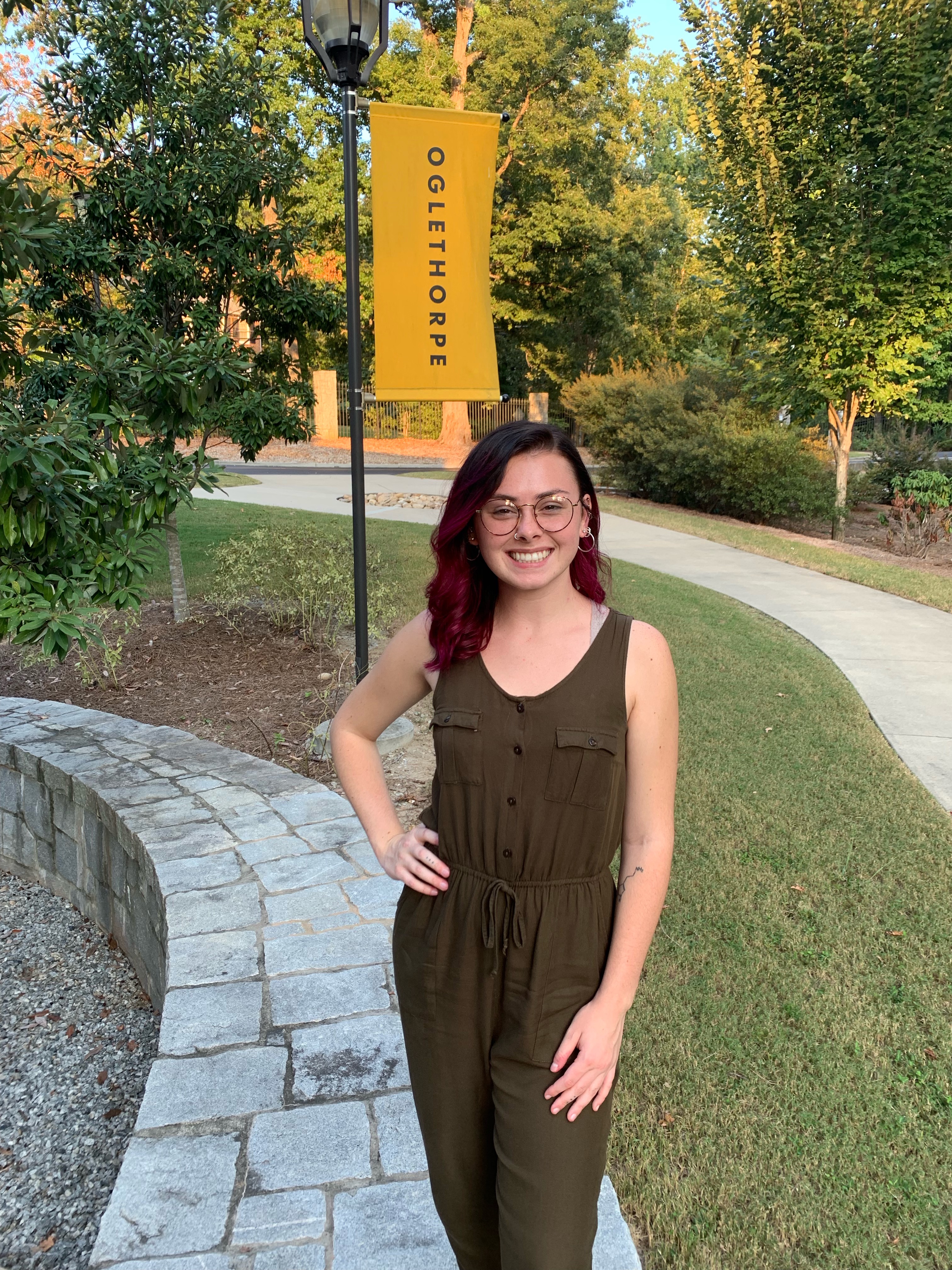 Mikayla Adams standing in front of the sidewalk and Oglethorpe flag